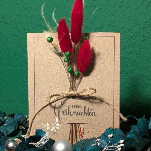Weihnachtskarte mit Trockenblumen in Rot und Grün